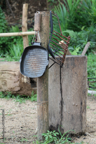 The old cookware hanging on the wooden pole