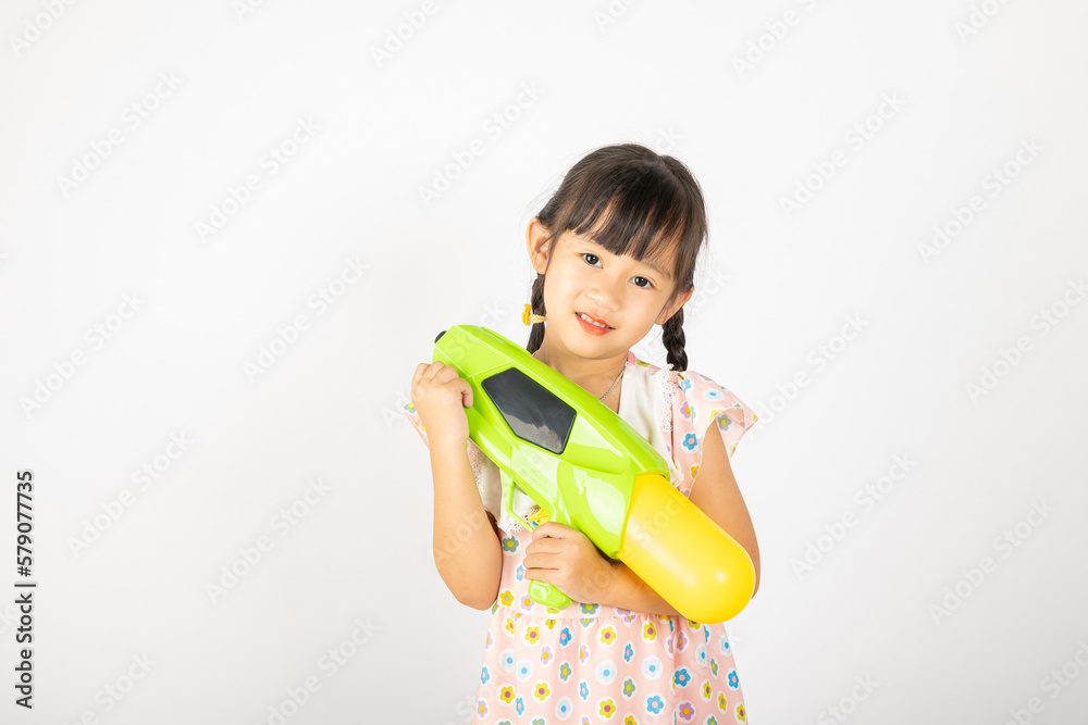 Happy Songkran Day, Asian little girl holding plastic water gun, Thai child funny hold toy water pistol and smile, isolated on white background, Thailand Songkran festival national culture concept Happy Songkran Day, Asian little girl holding plastic water gun, Thai child funny hold toy water pistol and smile, isolated on white background, Thailand Songkran festival national culture concept