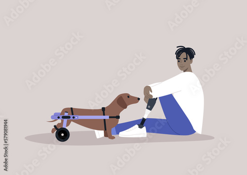 A young male African character with a prosthetic leg sitting on a floor, a sausage dog with a moving disability standing nearby