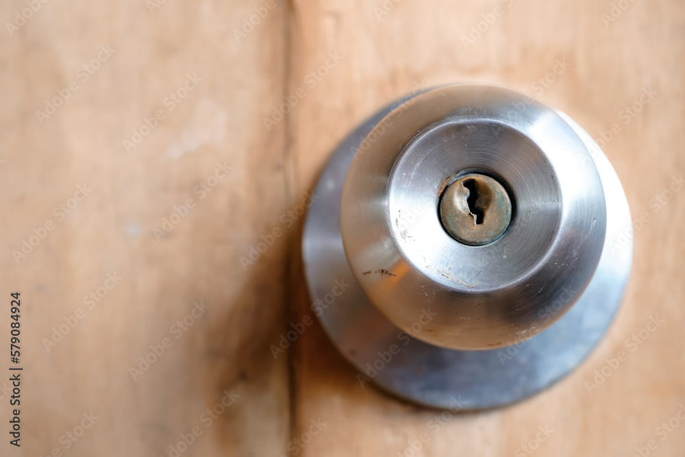 Stainless doorknob and keyhole on old wooden door, Macro shot Stainless doorknob and keyhole on old wooden door, Macro shot