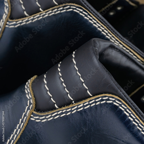 Detail of blue leather boots with white contrast stitching