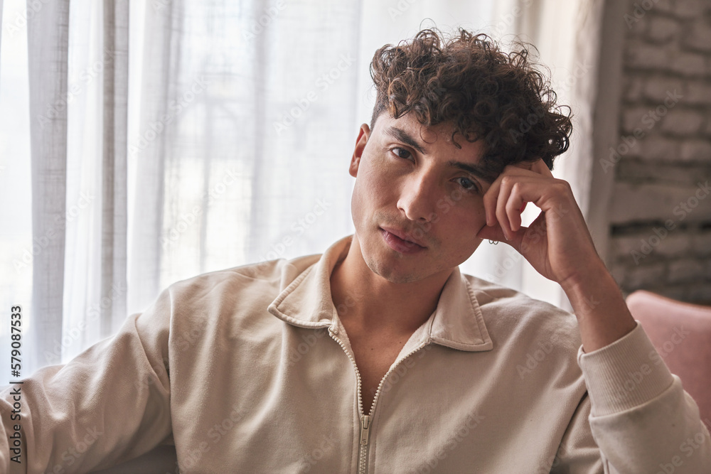 An intimate close-up portrait of a thoughtful young man at home, captured in natural light. An intimate close-up portrait of a thoughtful young man at home, captured in natural light.