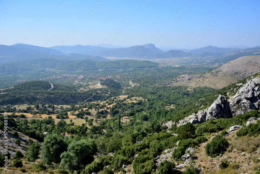 The view from the top of the mountain to the valley with trees and mountain range