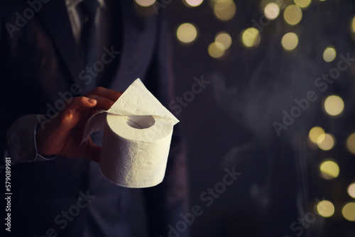 Obraz na płótnie Businessman Holding a pile of Toilet Paper, copy space