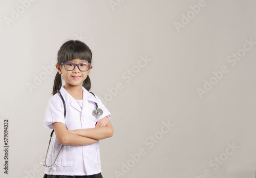 Kid doctor holding a stethoscope. Kid role playing doctor.
