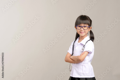 Kid doctor holding a stethoscope isolate on background. Kid role playing doctor. Preschool kid.

