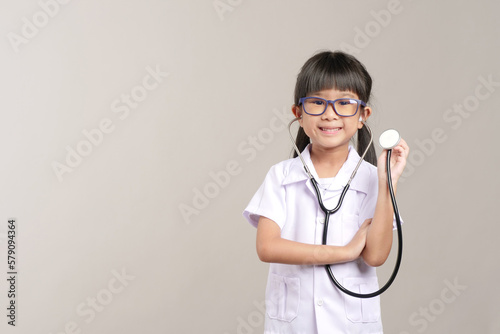 Kid doctor holding a stethoscope. Kid role playing doctor.

