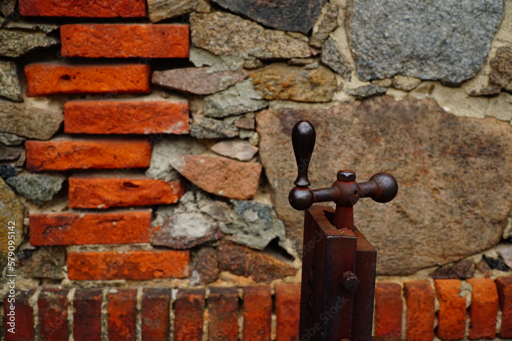 An old rusty metal grip on the brick wall background