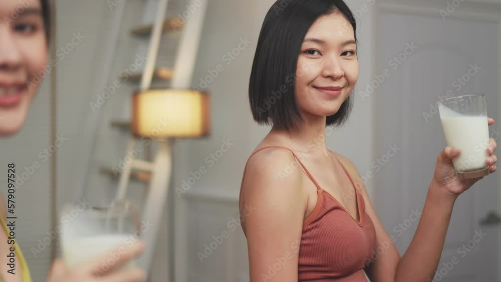Attractive fitness asian woman finishing workout and drinking protein milk shake vitamins after training at home. Bodybuilding. Healthy lifestyle. Attractive fitness asian woman finishing workout and drinking protein milk shake vitamins after training at home. Bodybuilding. Healthy lifestyle.
