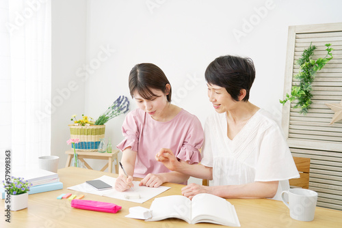家で母親と勉強する娘