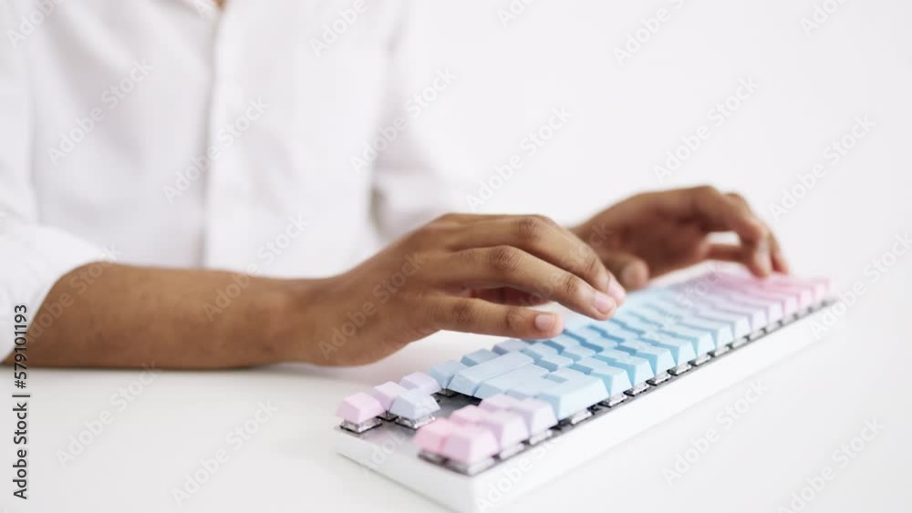 Closeup of man typing on computer keyboard in all white room, work process Closeup of man typing on computer keyboard in all white room, work process