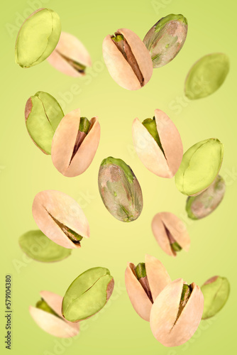 Levitation of pistachios on a green background.