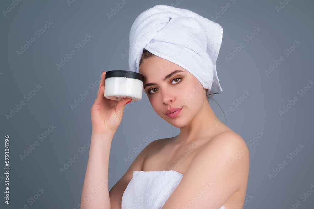 Beauty portrait of a beautiful half naked woman applying face cream isolated on studio background. Skin care product. Moisturizing creme on face. Perfect skin, morning routine. Beauty portrait of a beautiful half naked woman applying face cream isolated on studio background. Skin care product. Moisturizing creme on face. Perfect skin, morning routine.