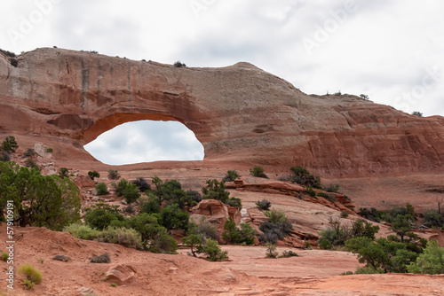 Scenic view on Wilson Arch, south of La Sal Junction, Utah, USA. Landmark in Arches National Park in the desert. Closeup of giant rock formation. Large natural arch in dry desert environment photo
