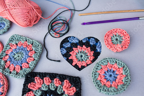 Closeup of crochet pattern in a heart, two hooks, other patterns