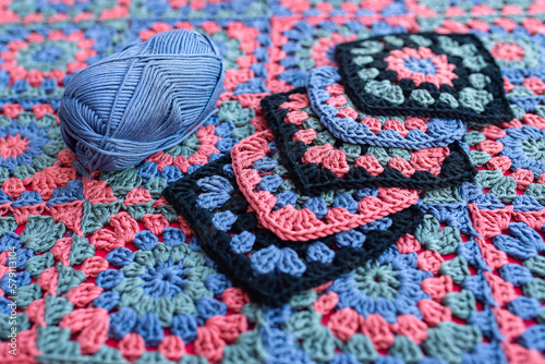 Granny square crochet motifs contrast colors and a skein of yarn