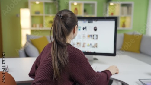 Young Asian woman ordering from e-commerce follows from computer and phone and shopping is completed. photo