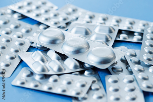 Different blister of pills. Medical and Global healthcare concept. Pharmaceutical industry. Light blue paper background with copy space.