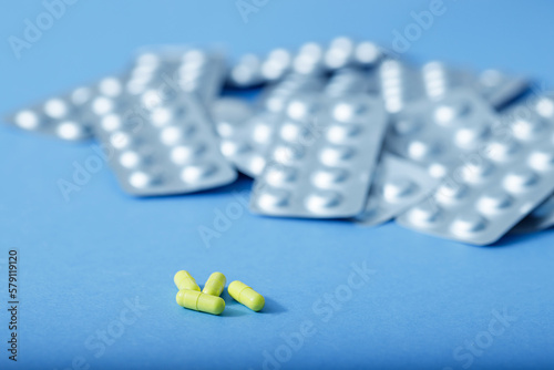 Yellow capsules and different blister of pills. Different pills. Medical and different concept of light blue paper background with copy space.