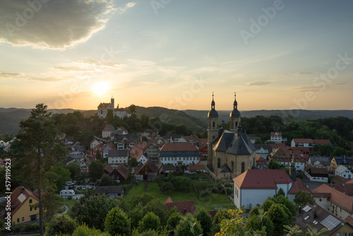 Burg Gössweinstein auf Hügel in Franken und Bayern mit Dorf zum Sonnenuntergang.
