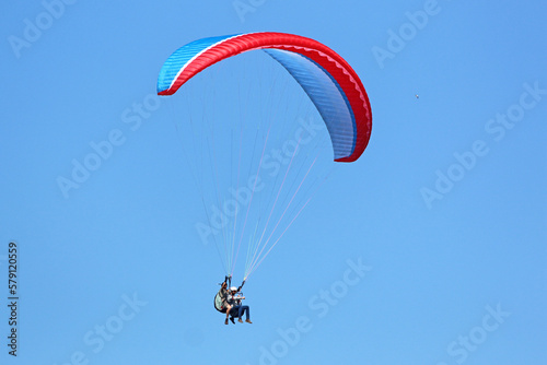 Tandem Paraglider flying in a blue sky