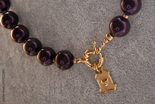 author beautiful  blackberry color pearls necklaces with heart pendant demonstrated on maneken. fashion and jewelry concept photo