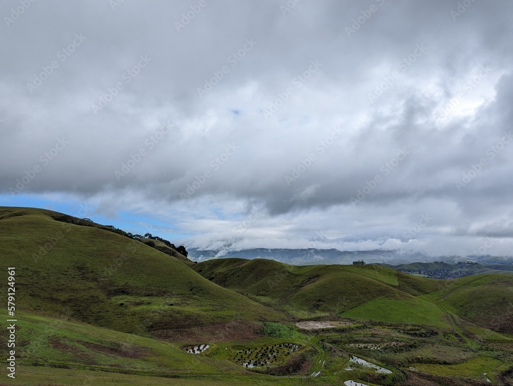 clouds over the mountains, green valley and hills landscape clouds over the mountains, green valley and hills landscape