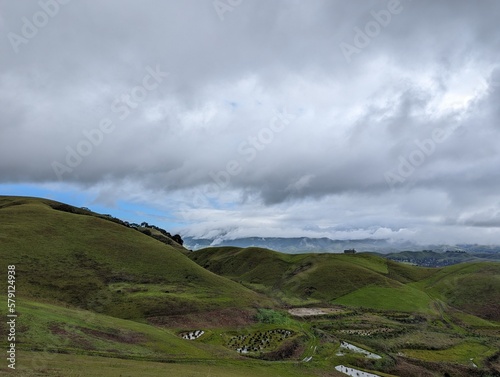 clouds over the mountains, green valley and hills landscape