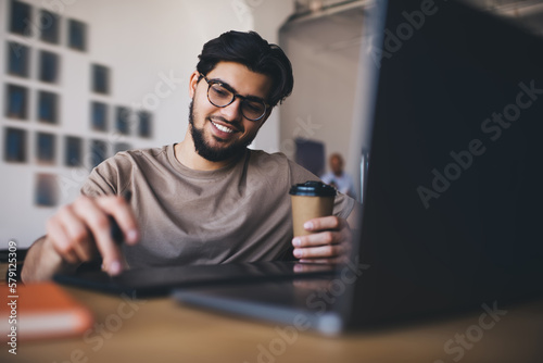 Happy man with laptop and coffee