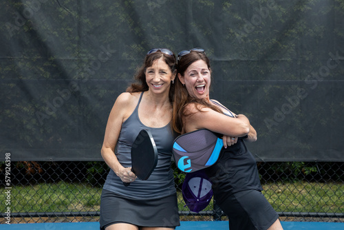 Two pickleball players posing with paddles