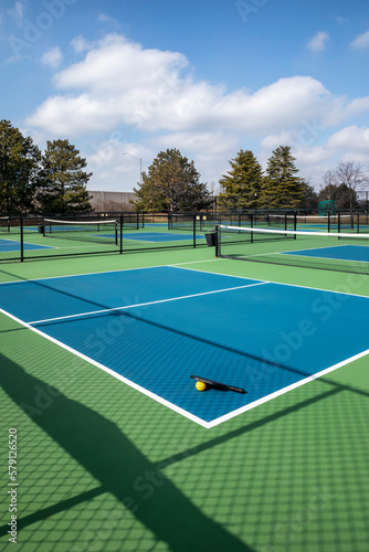 Pickleball Court Complex with Paddle and Yellow Ball © pics721