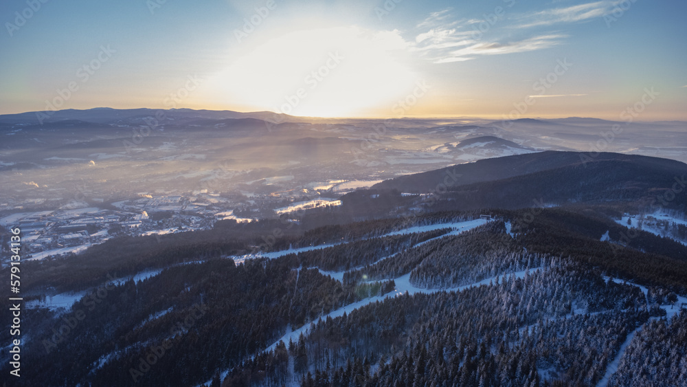 Obraz premium A bird's eye view of snowy Liberec at sunrise. Photographed on Jested Ridge by drone in winter.