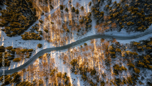 Drone top down on the road and a forest. A bird's eye view of the snowy landscape with the sun shining. Taken on the Jested Ridge in Liberec Region. 