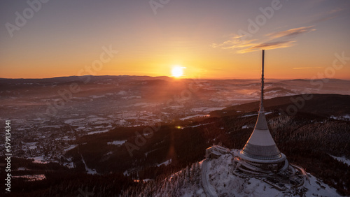 A bird's eye view of snow-covered Jested at sunrise. Photographed on the Jested ridge by drone. Beautiful winter landscape in Liberec region.