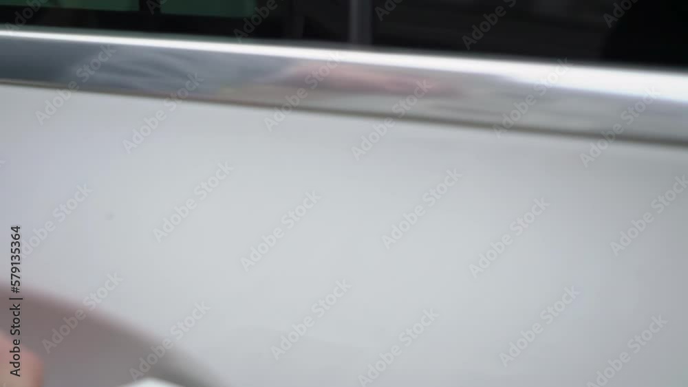 A man in a suit opens the back door of a premium car. Luxurious white vehicle. The driver takes the door handle with his hand. VIP taxi transport service. A man in a suit opens the back door of a premium car. Luxurious white vehicle. The driver takes the door handle with his hand. VIP taxi transport service.