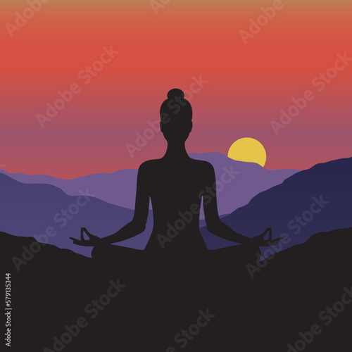 Silhouette of a woman meditating in the mountains at beautiful sunrise 