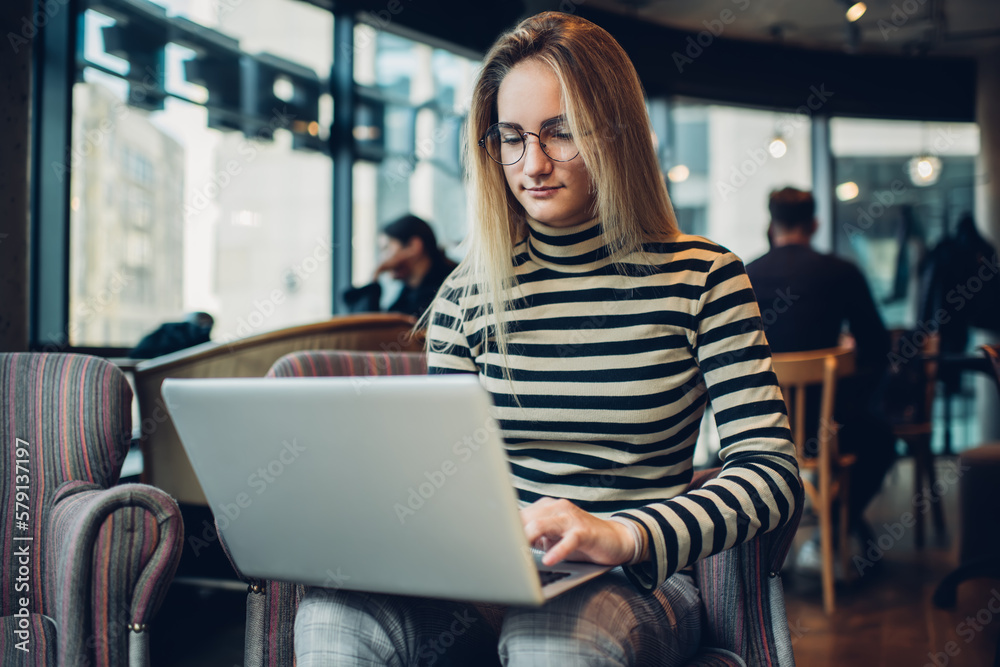 Focused woman using computer in cafe