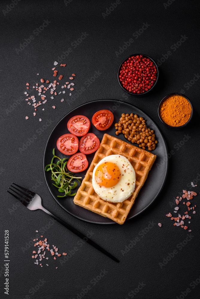Delicious hearty breakfast consisting of a fried egg, Belgian waffle Delicious hearty breakfast consisting of a fried egg, Belgian waffle