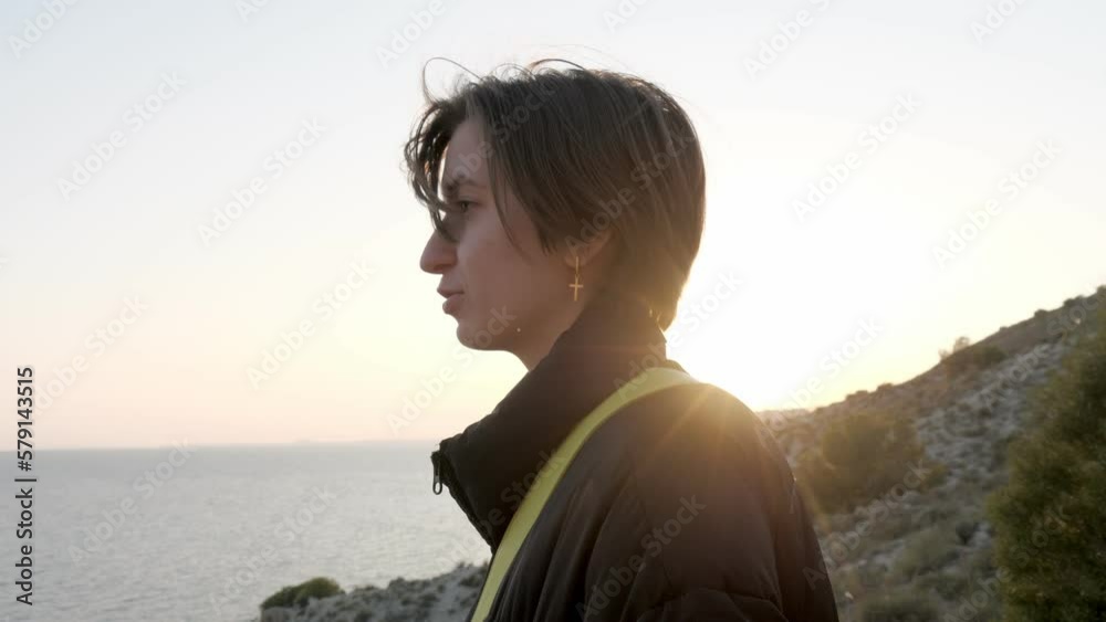 Teenager girl talks walking on coastal path, sunset sea ocean in background. Enjoying the time with nature. Teenager girl talks walking on coastal path, sunset sea ocean in background. Enjoying the time with nature.