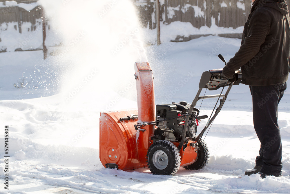 A portable snow blower powered by gasoline. Snow removal in winter. A portable snow blower powered by gasoline. Snow removal in winter.
