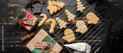Decorating of Christmas gingerbread cookies on dark wooden background