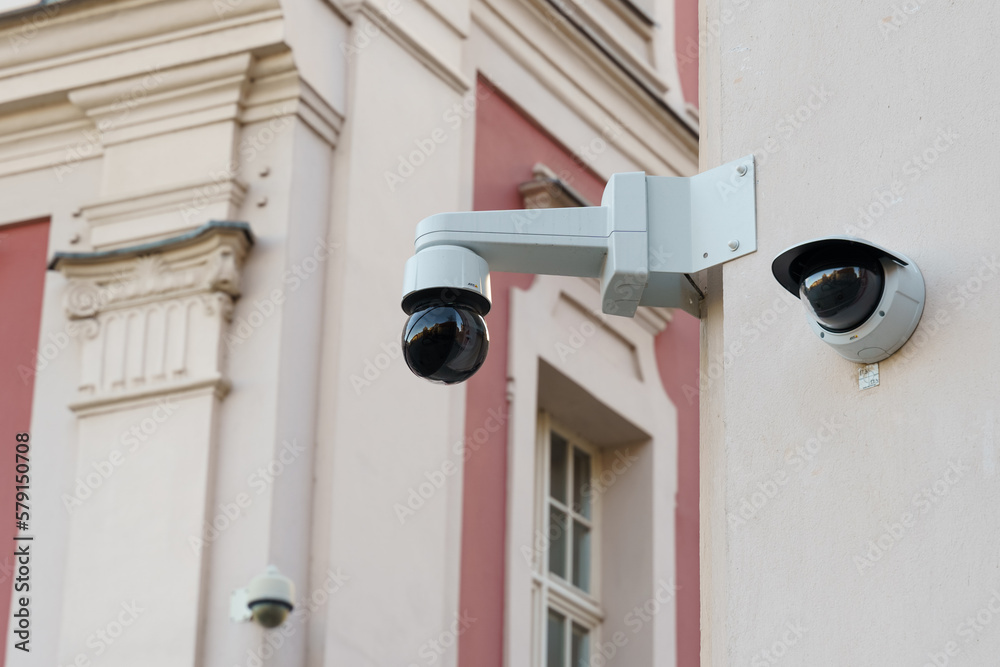 Surveillance cameras installed on the wall of an old building.