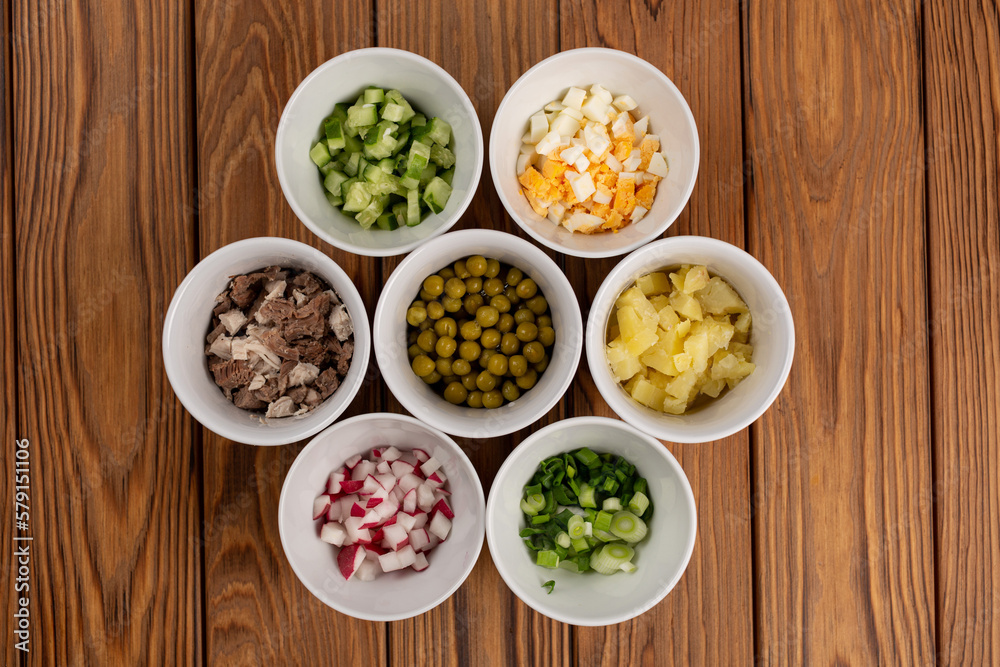 The plates are laid out with chopped ingredients for salad The plates are laid out with chopped ingredients for salad