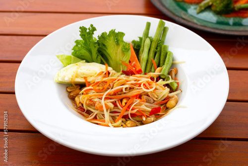 Spicy papaya salad in white plate