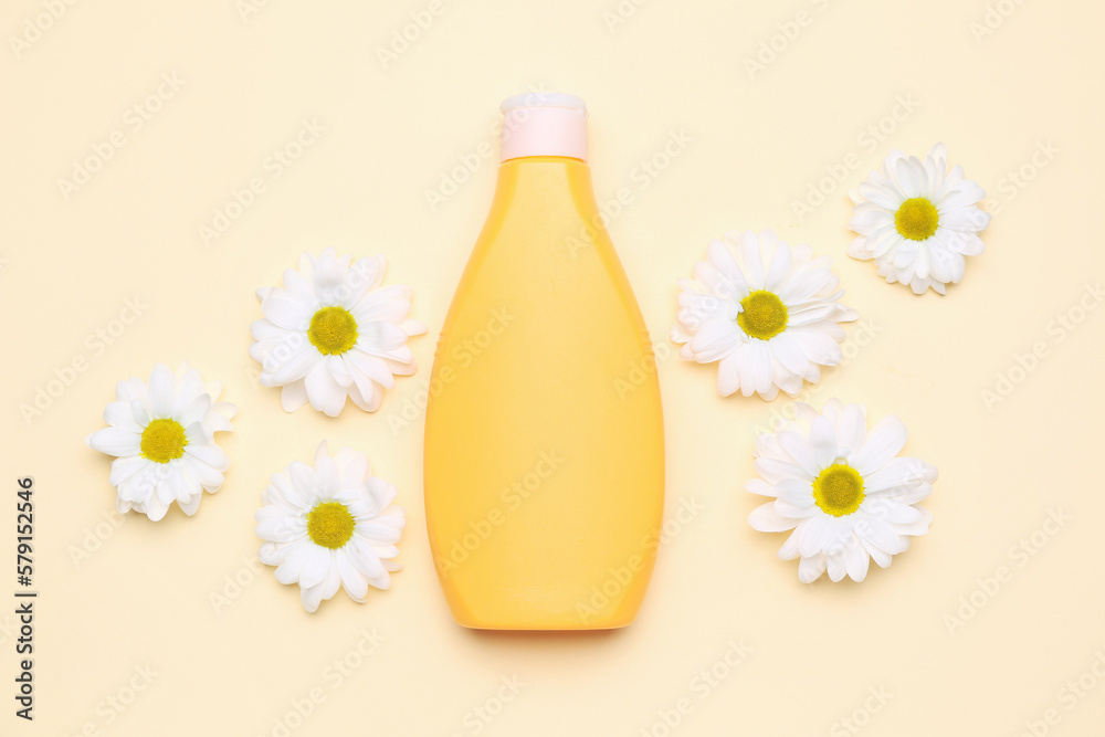 Bottle of cosmetic product and chamomile flowers on color background Bottle of cosmetic product and chamomile flowers on color background