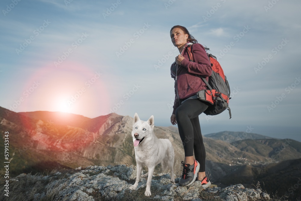 Young woman and domestic dog on pique mountain