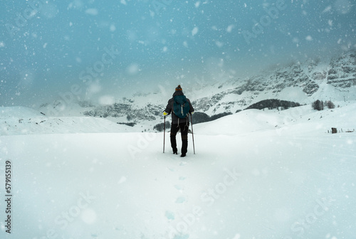 Hiker, with backpack in winter wilderness during extreme snow storm.