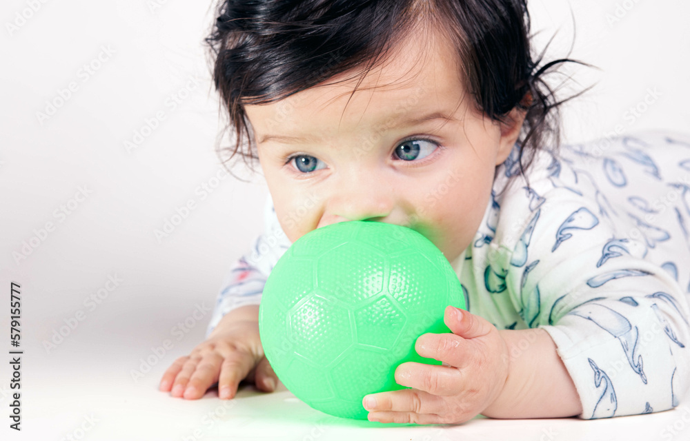 Baby with green eyes playing with a ball Baby with green eyes playing with a ball