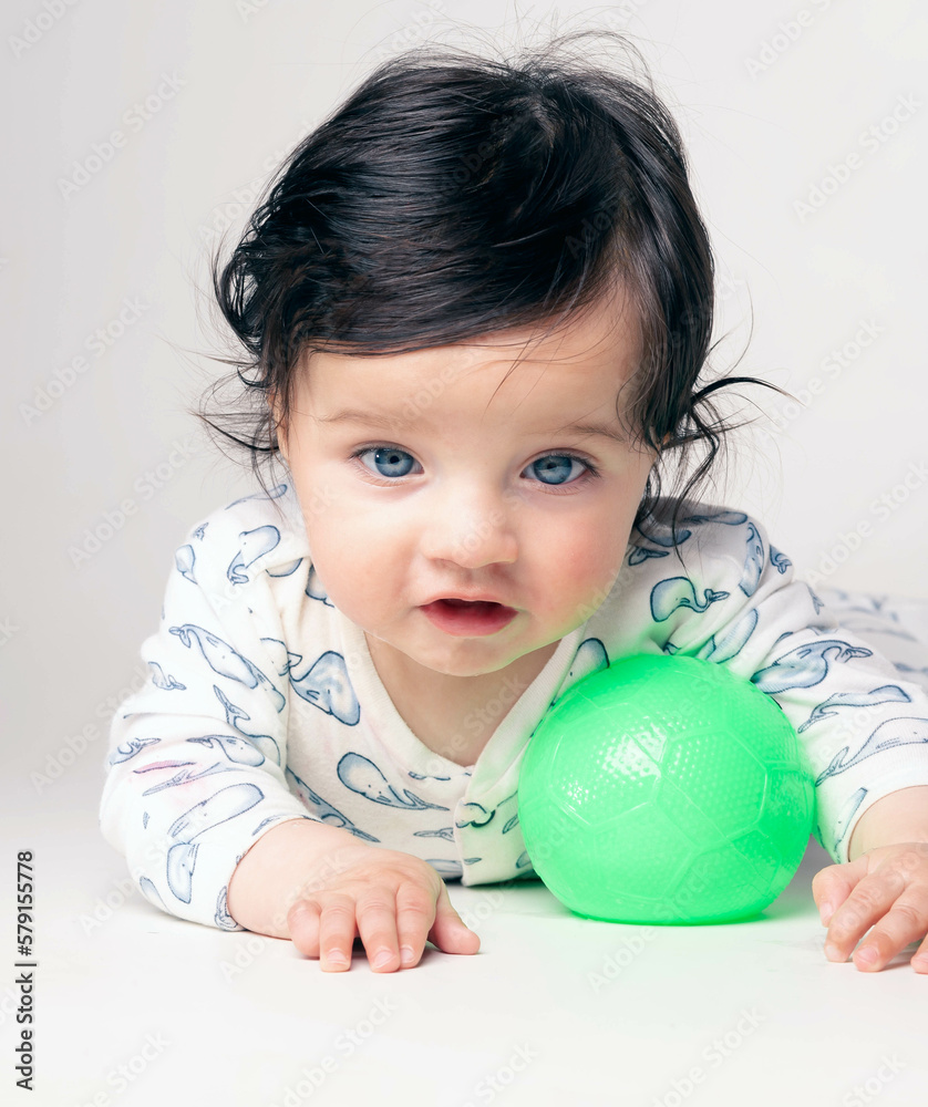 Baby with green eyes playing with a ball Baby with green eyes playing with a ball