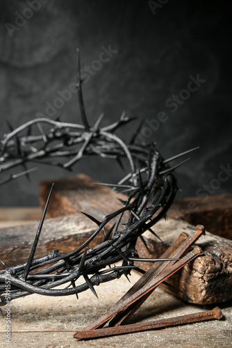 Fotografija Crown of thorns, nails and cross on wooden table, closeup